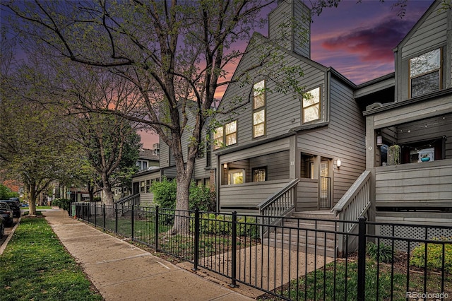 2 Acoma St Unit 11, Denver, CO 80223 - view of side of property with a fenced front yard and a chimney