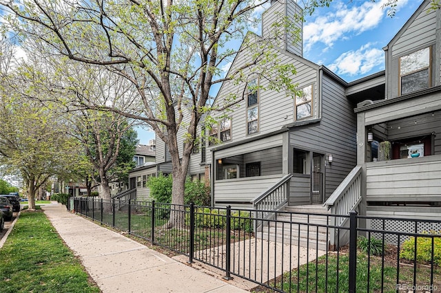 2 Acoma St Unit 11, Denver, CO 80223 - view of property exterior featuring a fenced front yard and a chimney