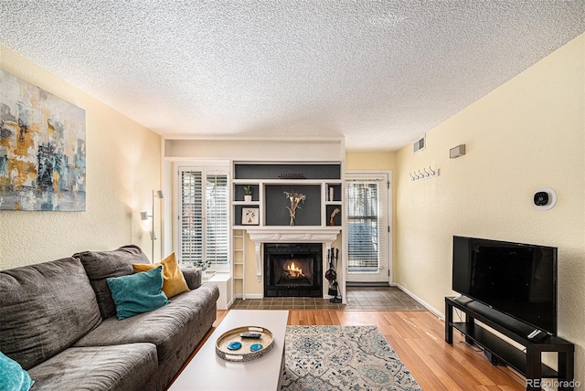2 Acoma St Unit 11, Denver, CO 80223 - living area with a fireplace with flush hearth, a textured ceiling, and wood finished floors