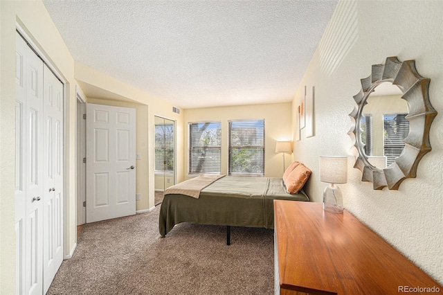 2 Acoma St Unit 11, Denver, CO 80223 - carpeted bedroom with a textured ceiling, a closet, and a textured wall