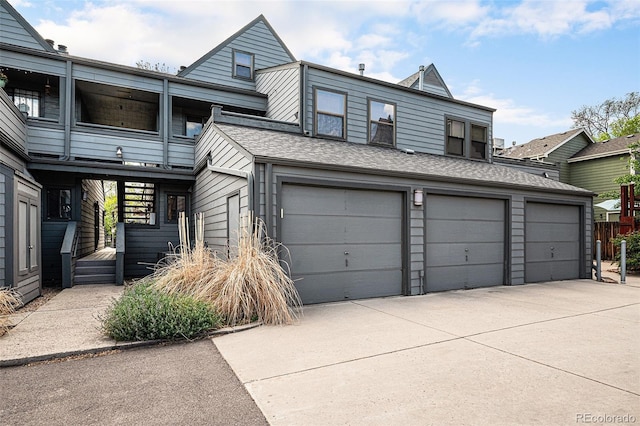 2 Acoma St Unit 11, Denver, CO 80223 - view of front of house with an attached garage, driveway, and a shingled roof