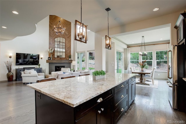 23451 E Rockinghorse Pkwy, Aurora, CO 80016 - kitchen featuring freestanding refrigerator, a chandelier, wood finished floors, light stone counters, and hanging light fixtures