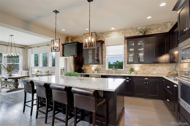 23451 E Rockinghorse Pkwy, Aurora, CO 80016 - kitchen featuring stainless steel appliances, a chandelier, a center island, decorative backsplash, and recessed lighting