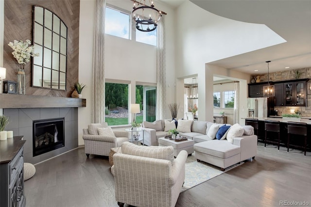 23451 E Rockinghorse Pkwy, Aurora, CO 80016 - living area featuring a chandelier, a towering ceiling, plenty of natural light, and wood finished floors