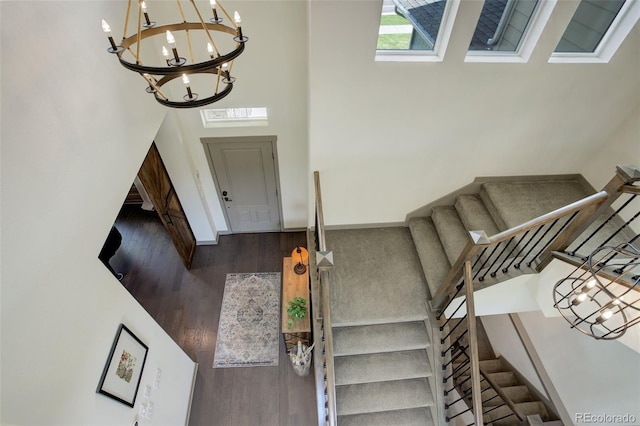 23451 E Rockinghorse Pkwy, Aurora, CO 80016 - stairs with a chandelier, a high ceiling, wood finished floors, and baseboards