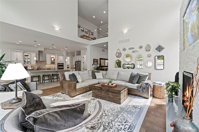 10525 Wild Fox Pl, Franktown, CO 80116 - living area featuring a high ceiling, light wood-type flooring, and a fireplace