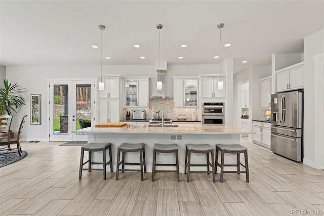 10525 Wild Fox Pl, Franktown, CO 80116 - kitchen with stainless steel appliances, wall chimney exhaust hood, tasteful backsplash, white cabinets, and recessed lighting
