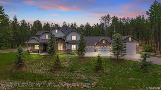 10525 Wild Fox Pl, Franktown, CO 80116 - view of front facade featuring driveway, stone siding, a garage, a lawn, and stucco siding