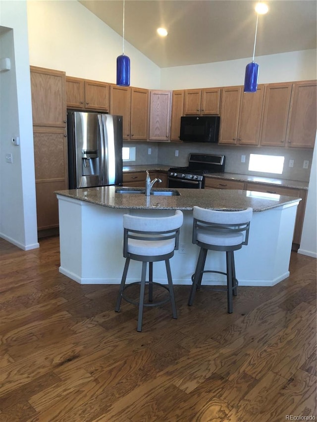 kitchen featuring appliances with stainless steel finishes, dark wood-type flooring, and a sink