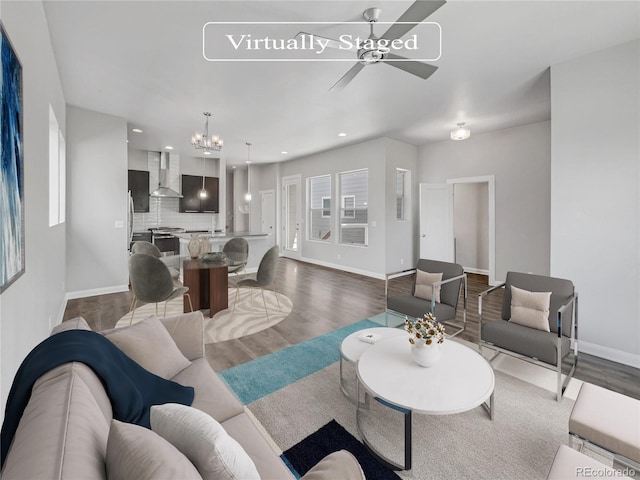 living room with ceiling fan with notable chandelier and wood-type flooring