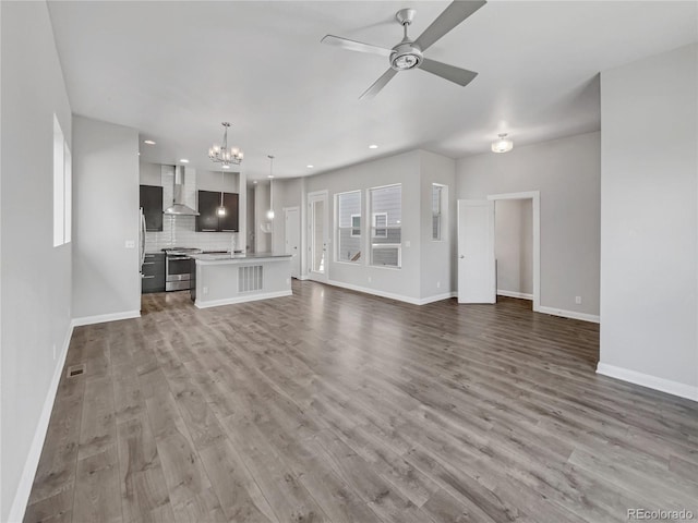 unfurnished living room with sink, wood-type flooring, and ceiling fan with notable chandelier