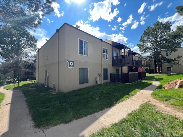 9995 E Harvard Ave Unit 261, Denver, CO 80231 - view of home's exterior with stucco siding, a balcony, and a yard