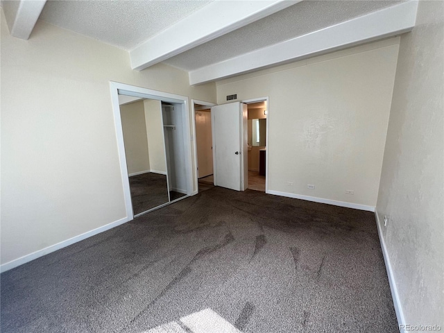 9995 E Harvard Ave Unit 261, Denver, CO 80231 - unfurnished bedroom with beam ceiling, carpet, a closet, and a textured ceiling