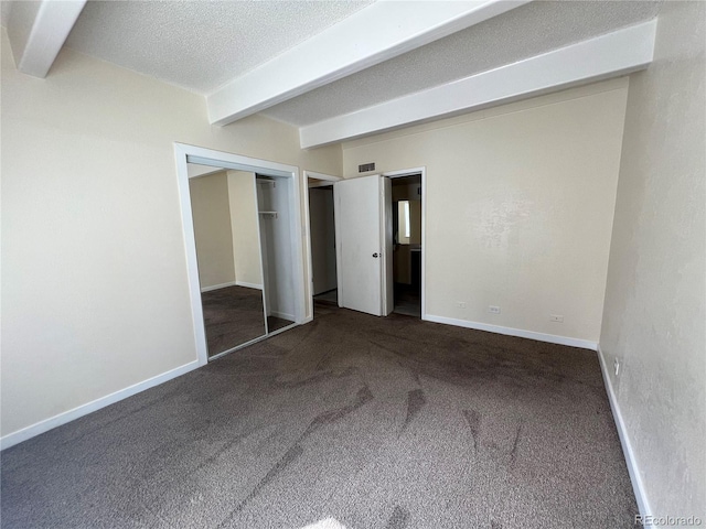 9995 E Harvard Ave Unit 261, Denver, CO 80231 - unfurnished bedroom featuring beamed ceiling, carpet, a textured ceiling, and a closet