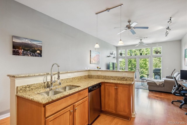 kitchen featuring light hardwood / wood-style floors, sink, dishwasher, and light stone countertops