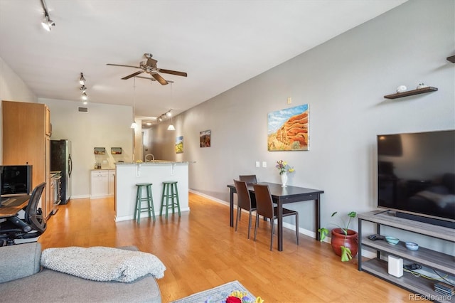 living room featuring ceiling fan and light hardwood / wood-style floors