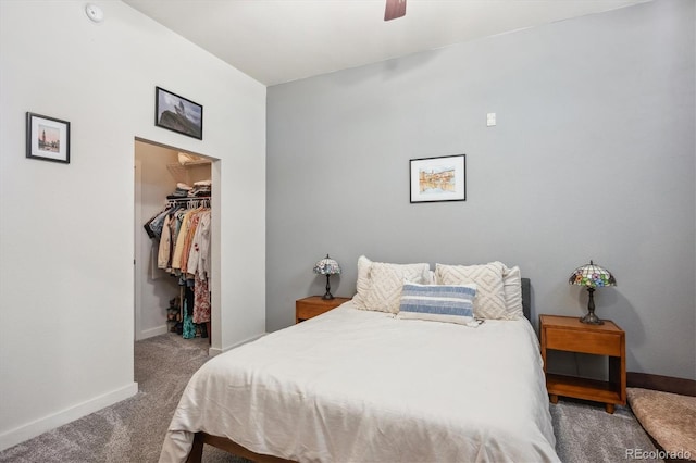 bedroom with a spacious closet, a closet, carpet flooring, and ceiling fan