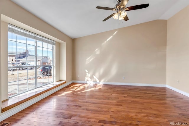 empty room with wood-type flooring, vaulted ceiling, and ceiling fan