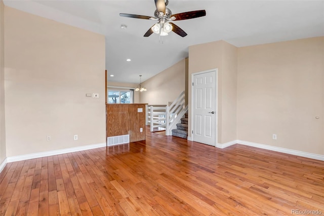 unfurnished room featuring hardwood / wood-style flooring and ceiling fan with notable chandelier