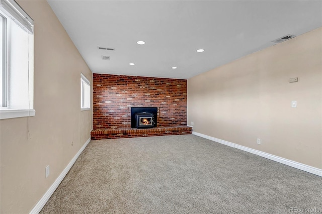 unfurnished living room with carpet floors and a brick fireplace