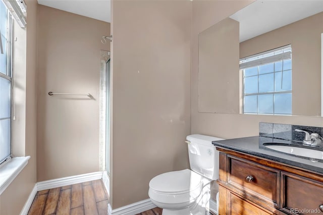 bathroom with vanity, toilet, a shower with door, and hardwood / wood-style floors