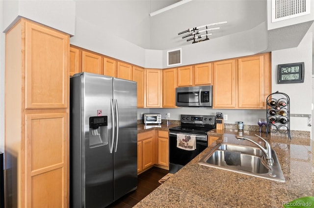 kitchen featuring sink, dark wood-type flooring, stainless steel appliances, light brown cabinetry, and kitchen peninsula