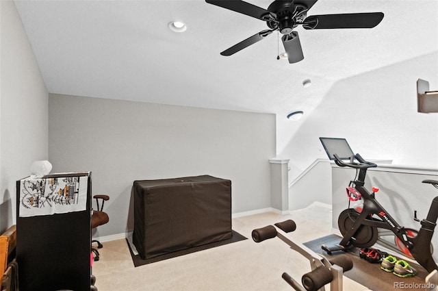 workout area featuring lofted ceiling, light colored carpet, and ceiling fan