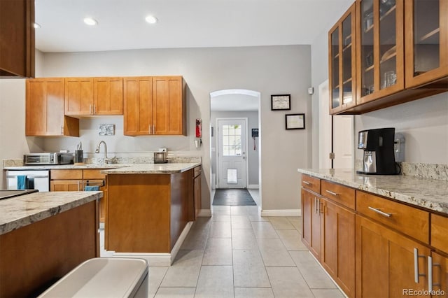 3429 N Adams St, Denver, CO 80205 - kitchen with light tile patterned flooring, light stone countertops, arched walkways, glass insert cabinets, and recessed lighting