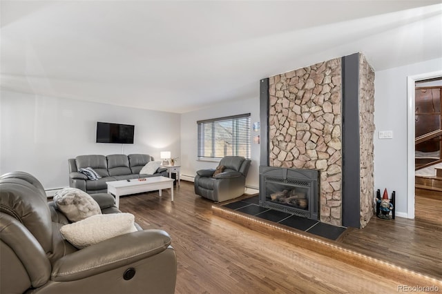 living room with a glass covered fireplace, a baseboard radiator, wood finished floors, and baseboards