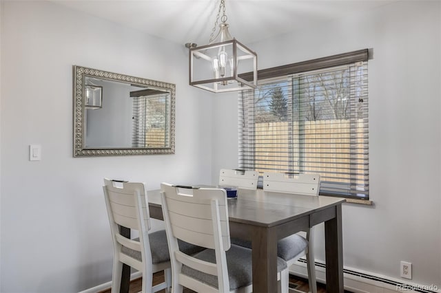 dining area with a baseboard heating unit, a wealth of natural light, and a notable chandelier