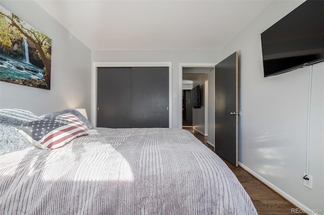 bedroom with a closet, baseboards, and wood finished floors