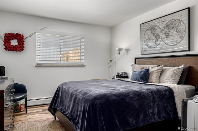 bedroom with a baseboard radiator and wood finished floors