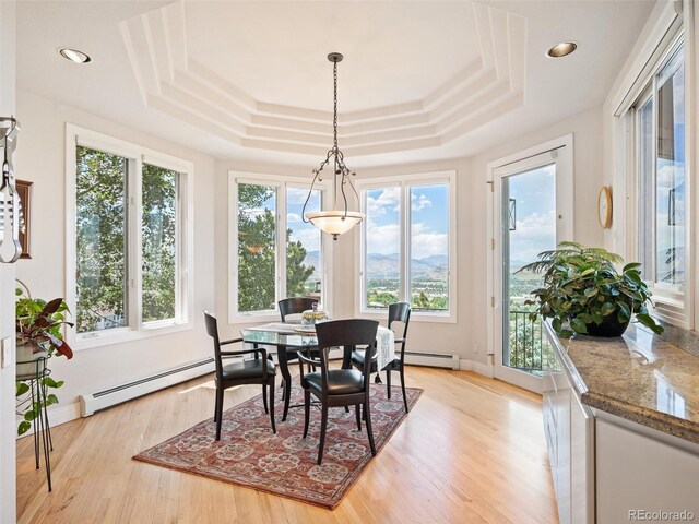 sunroom / solarium featuring a tray ceiling and a baseboard heating unit