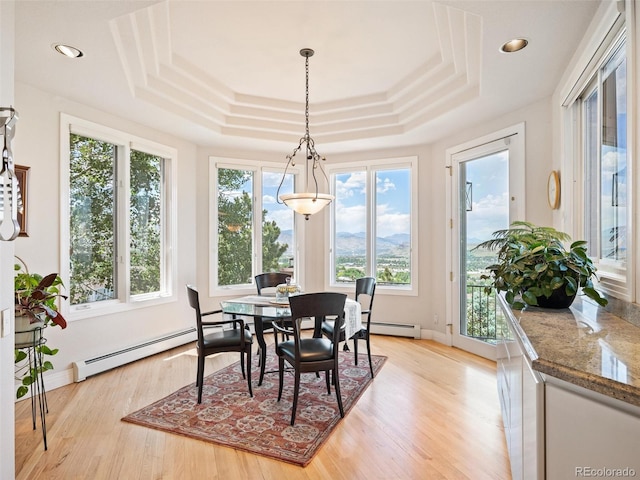 dining space with baseboard heating, a raised ceiling, light wood-style flooring, and recessed lighting