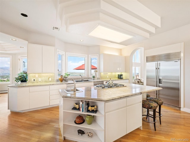 kitchen with white cabinetry, stainless steel appliances, and a kitchen island