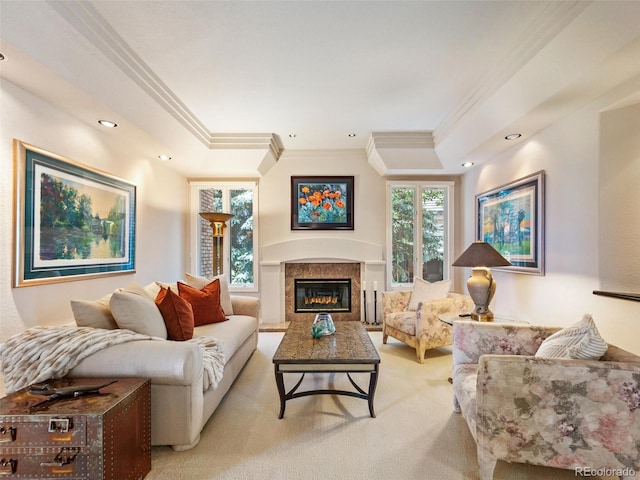 living room with ornamental molding, a premium fireplace, light carpet, and a raised ceiling