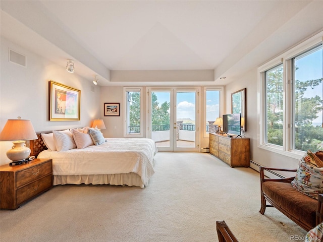 carpeted bedroom with access to outside, french doors, a raised ceiling, and a baseboard heating unit