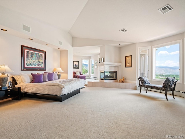 carpeted bedroom featuring a tiled fireplace and visible vents