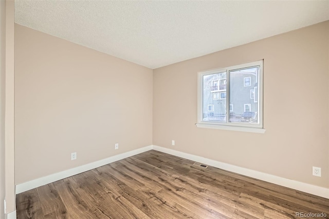 empty room featuring hardwood / wood-style floors and a textured ceiling