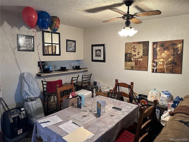 dining room featuring ceiling fan and a textured ceiling