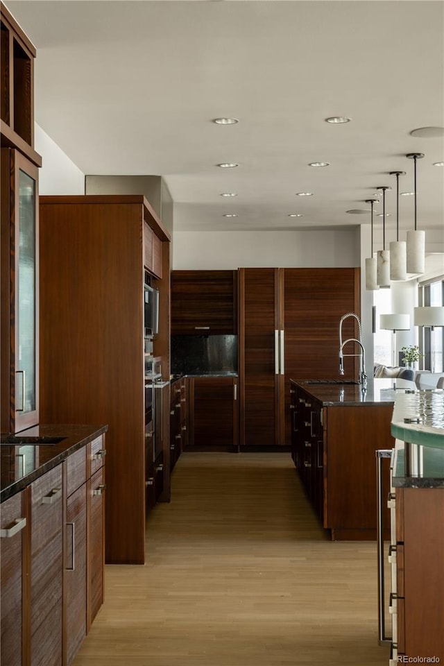 kitchen featuring pendant lighting, sink, and light hardwood / wood-style flooring