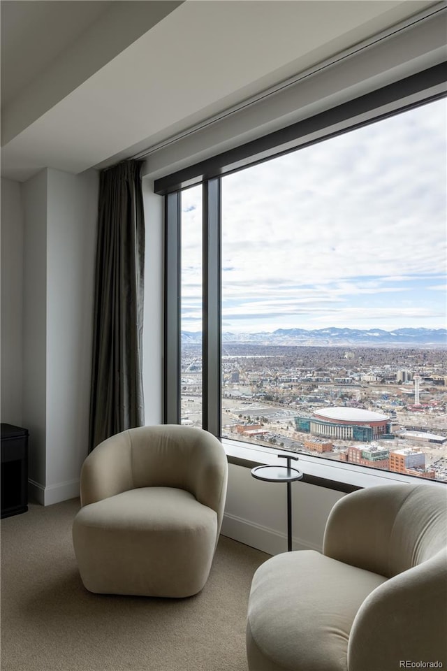 living area with light colored carpet, a mountain view, and a wealth of natural light