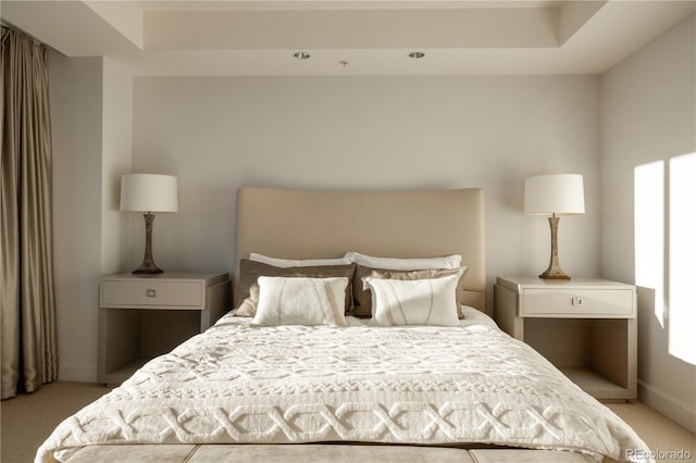 carpeted bedroom with a tray ceiling