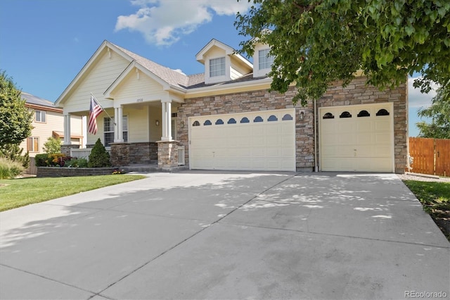 12522 Locust Way, Thornton, CO 80602 - view of front of property featuring concrete driveway, a garage, stone siding, and a porch