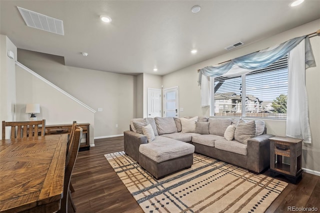 living room featuring wood finished floors, visible vents, and baseboards