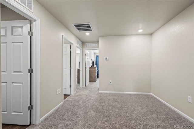 corridor with visible vents, carpet floors, and baseboards