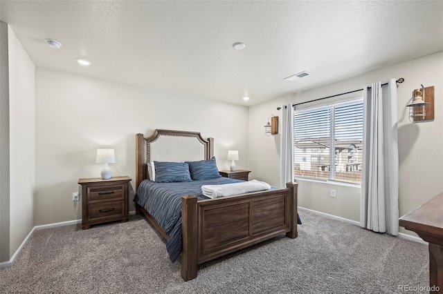 carpeted bedroom featuring baseboards, visible vents, and a textured ceiling