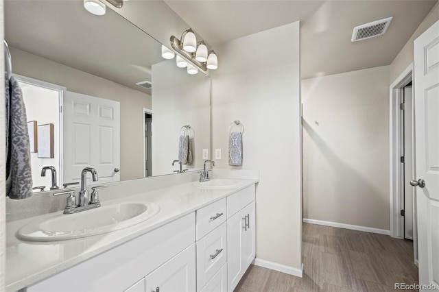 full bathroom featuring a sink, visible vents, baseboards, and double vanity