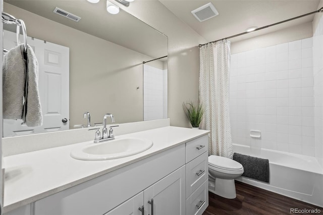 bathroom featuring visible vents, toilet, vanity, and wood finished floors