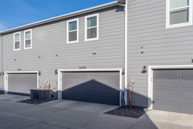 view of home's exterior with a garage and central AC